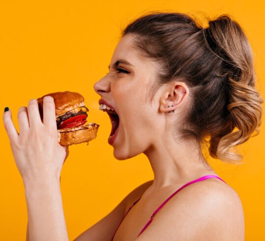 Girl is holding a tasty hamburger and is going to eating it